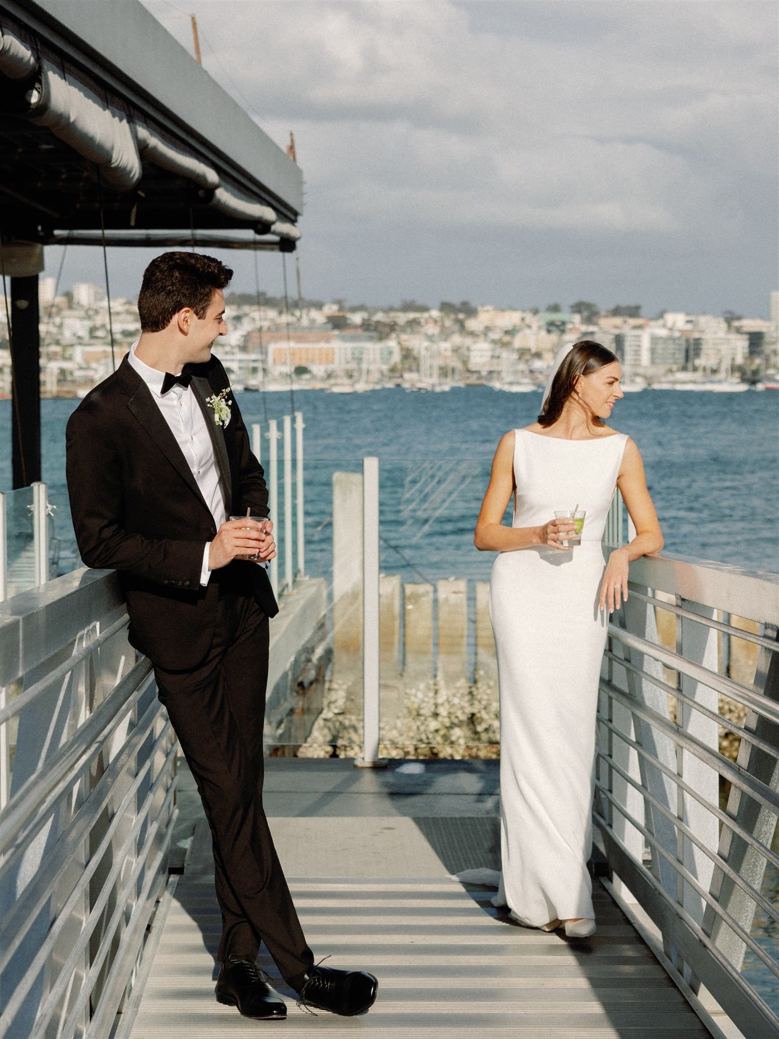 Bride and groom on dock overlooking the bay at Coasterra