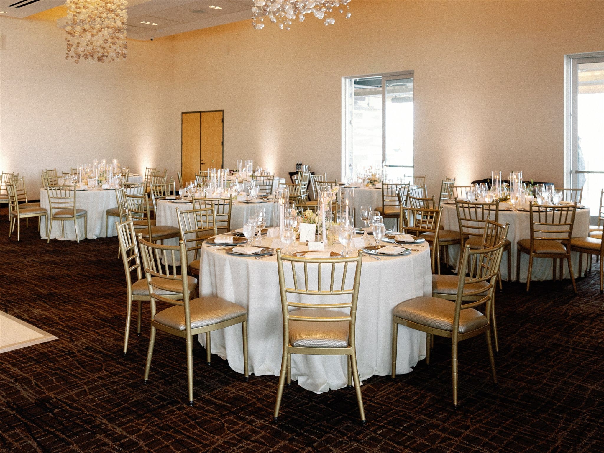 Wedding reception room with ivory linens and gold chiavari chairs