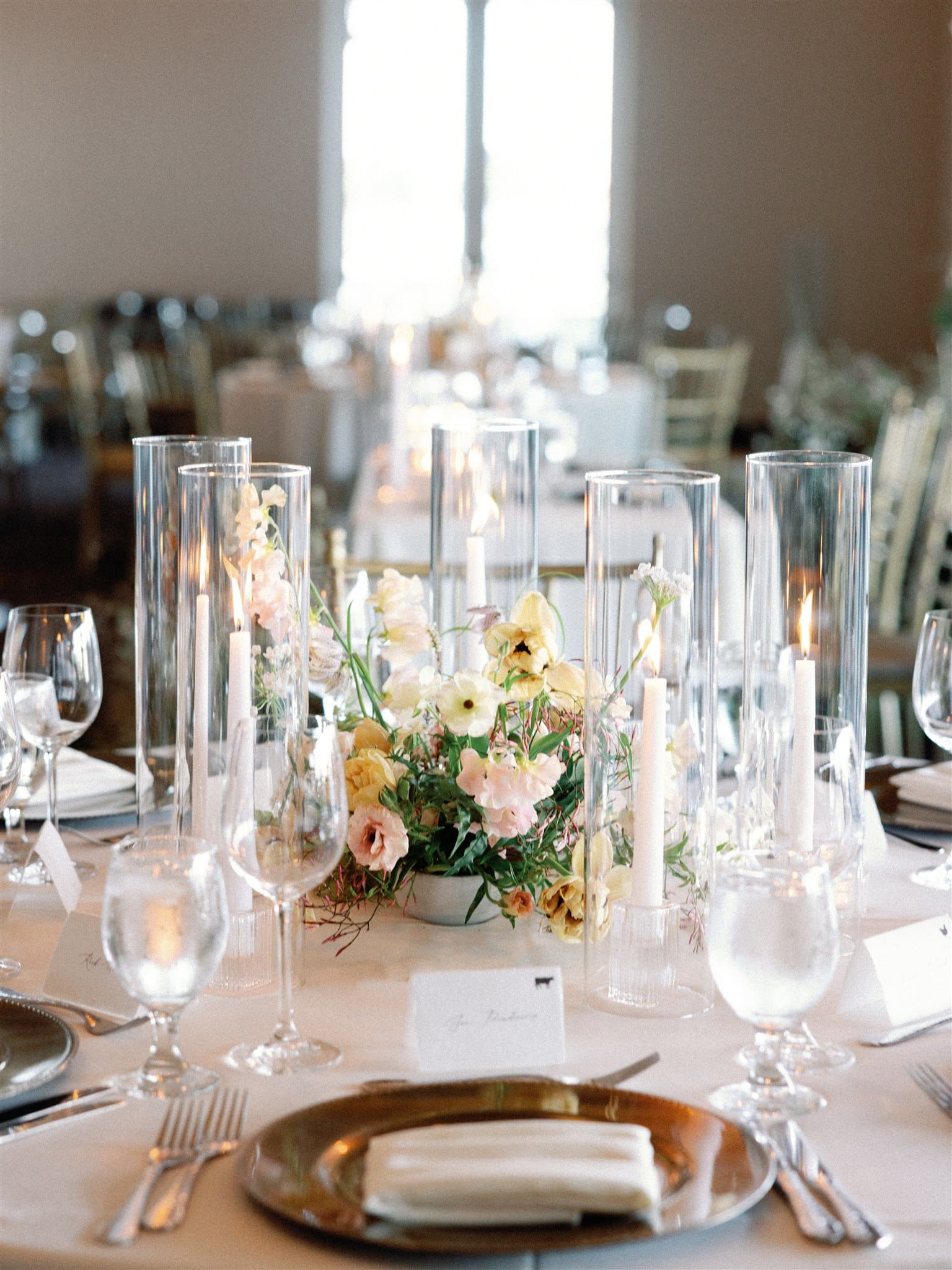 Wedding reception centerpiece with tall candles and delicate florals