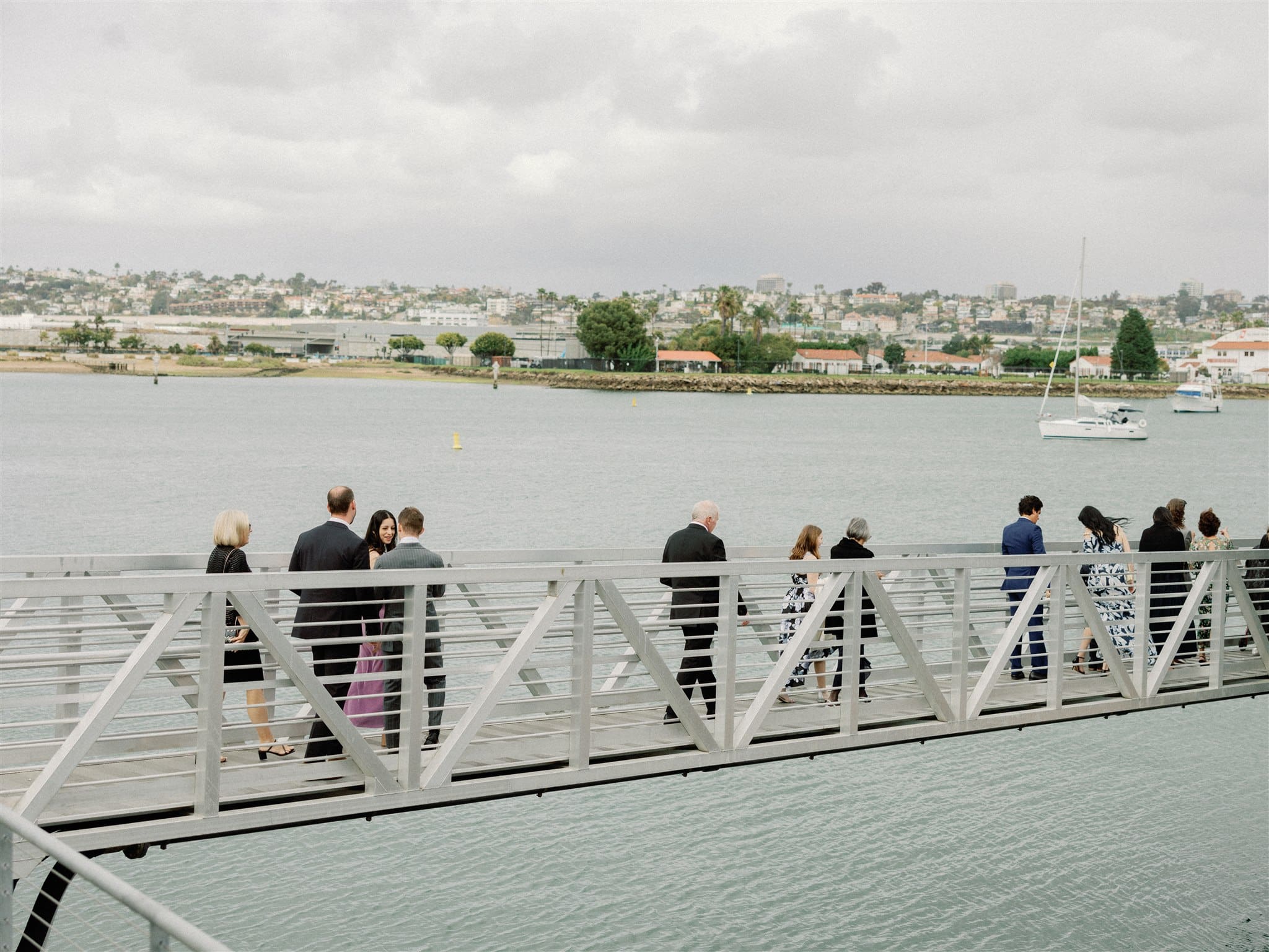 Wedding guests on walkway over the bay