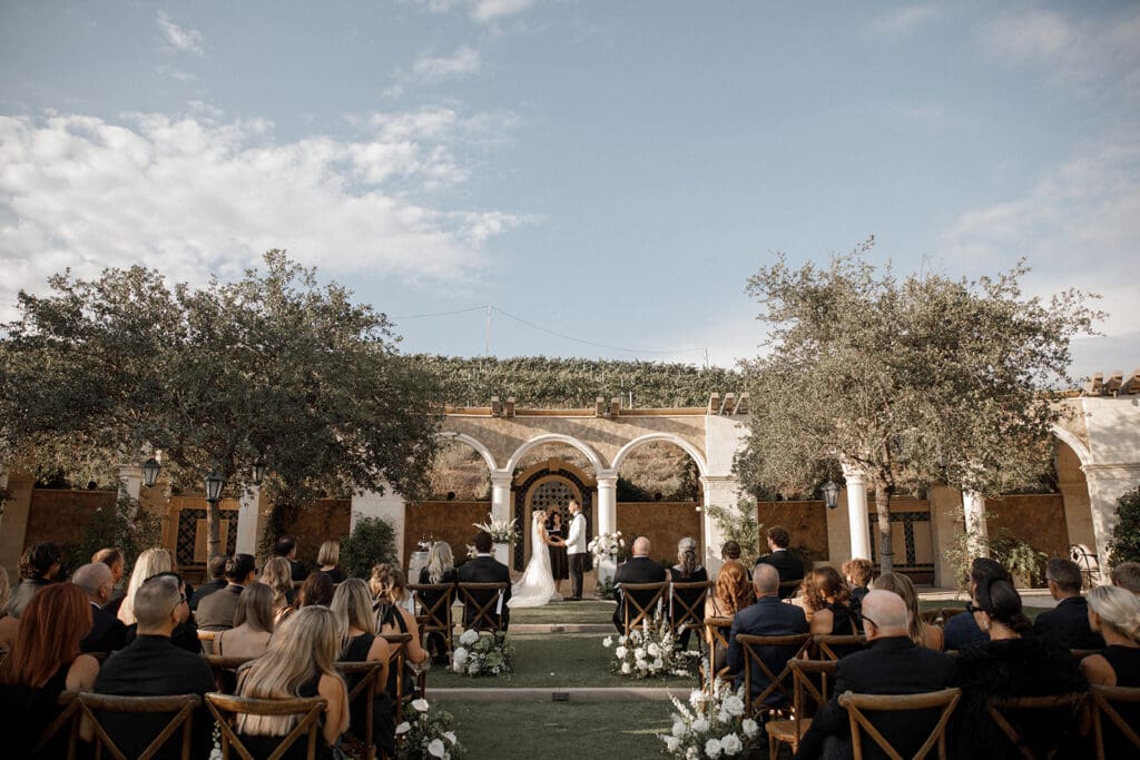 Green and white San Diego Wedding color Palettes ceremony with couple