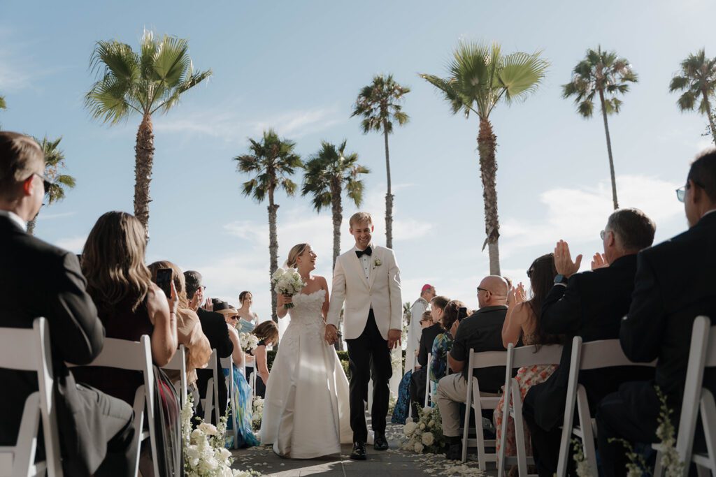 A happy wedding couple smiling after their ceremony, captured for a wedding vendor tipping guide to illustrate gratitude and celebration.